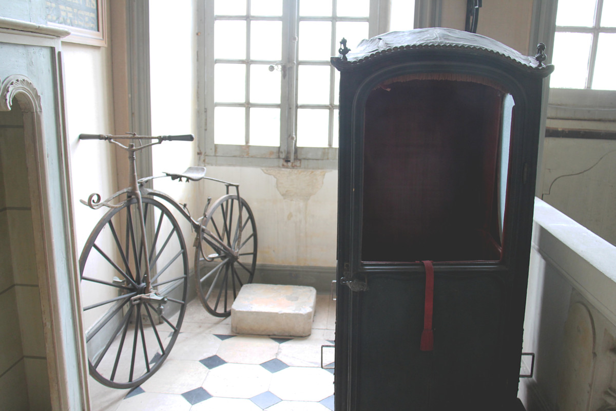 Chaise à porteur et vélocipède dans le hall du musée Dupuy-Mestreau
